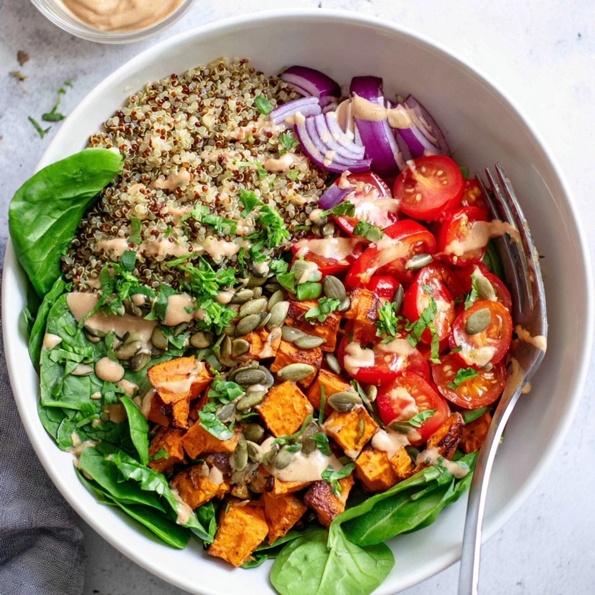 Vibrant Lentil Quinoa Meal Bowls with roasted veggies, tahini dressing, and fresh herbs.