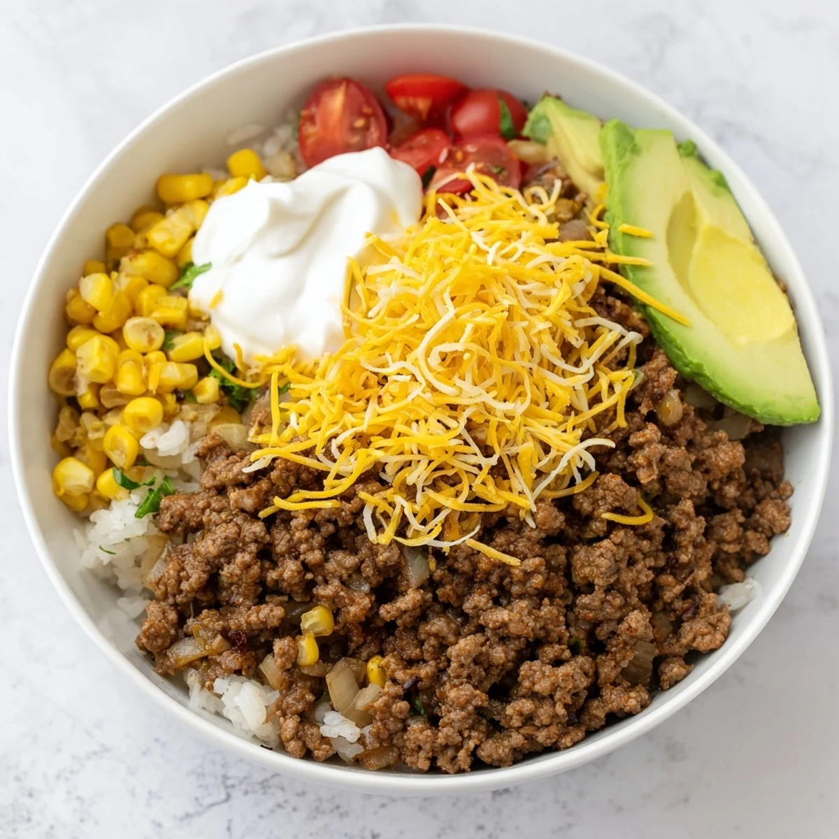 Close-up shot of sizzling ground beef seasoned with cumin and smoked paprika in a hot skillet for Beef Burrito Bowls.
