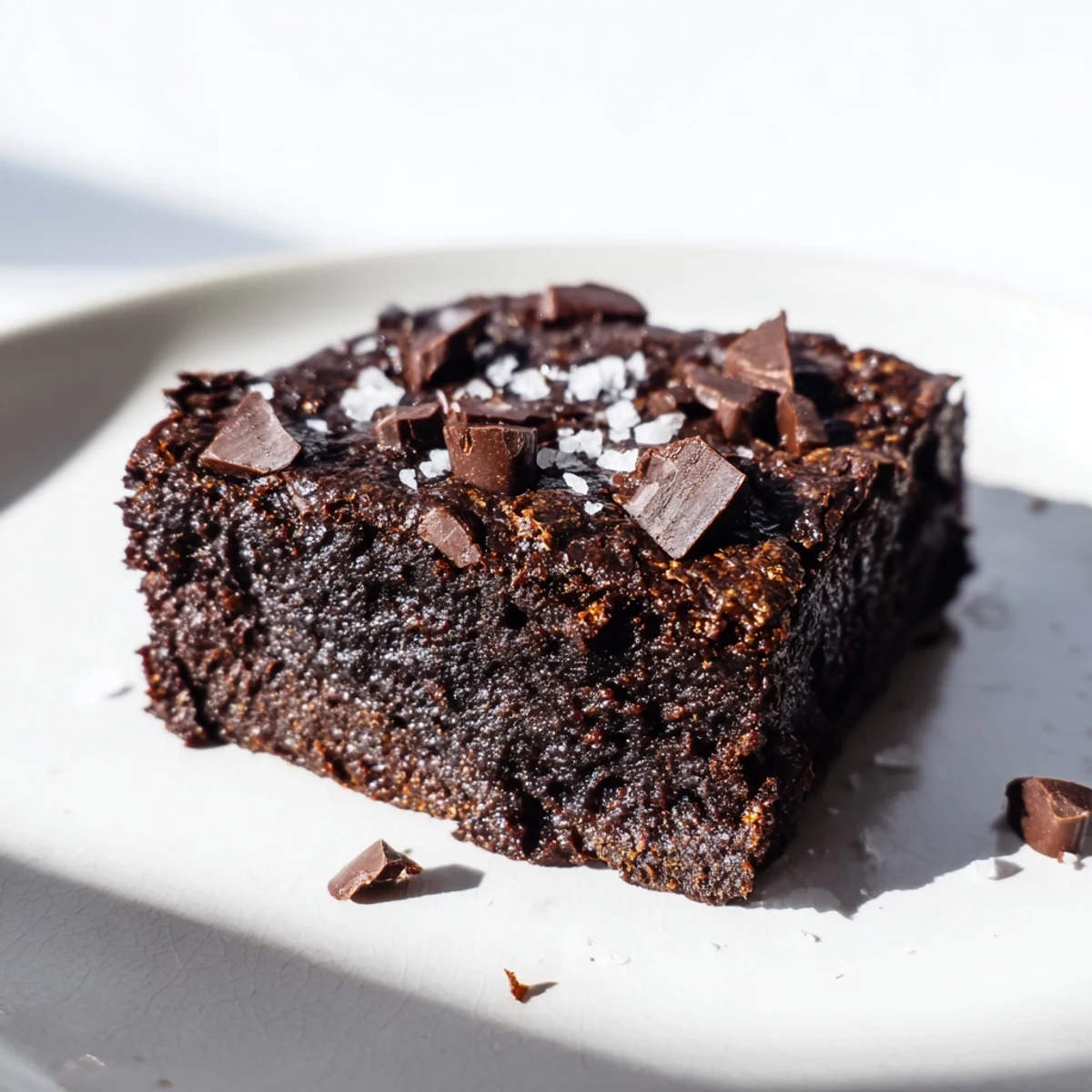 Gluten-Free Almond Flour Brownies with Sea Salt, fudgy and rich with chocolate chips on a rustic wooden board.