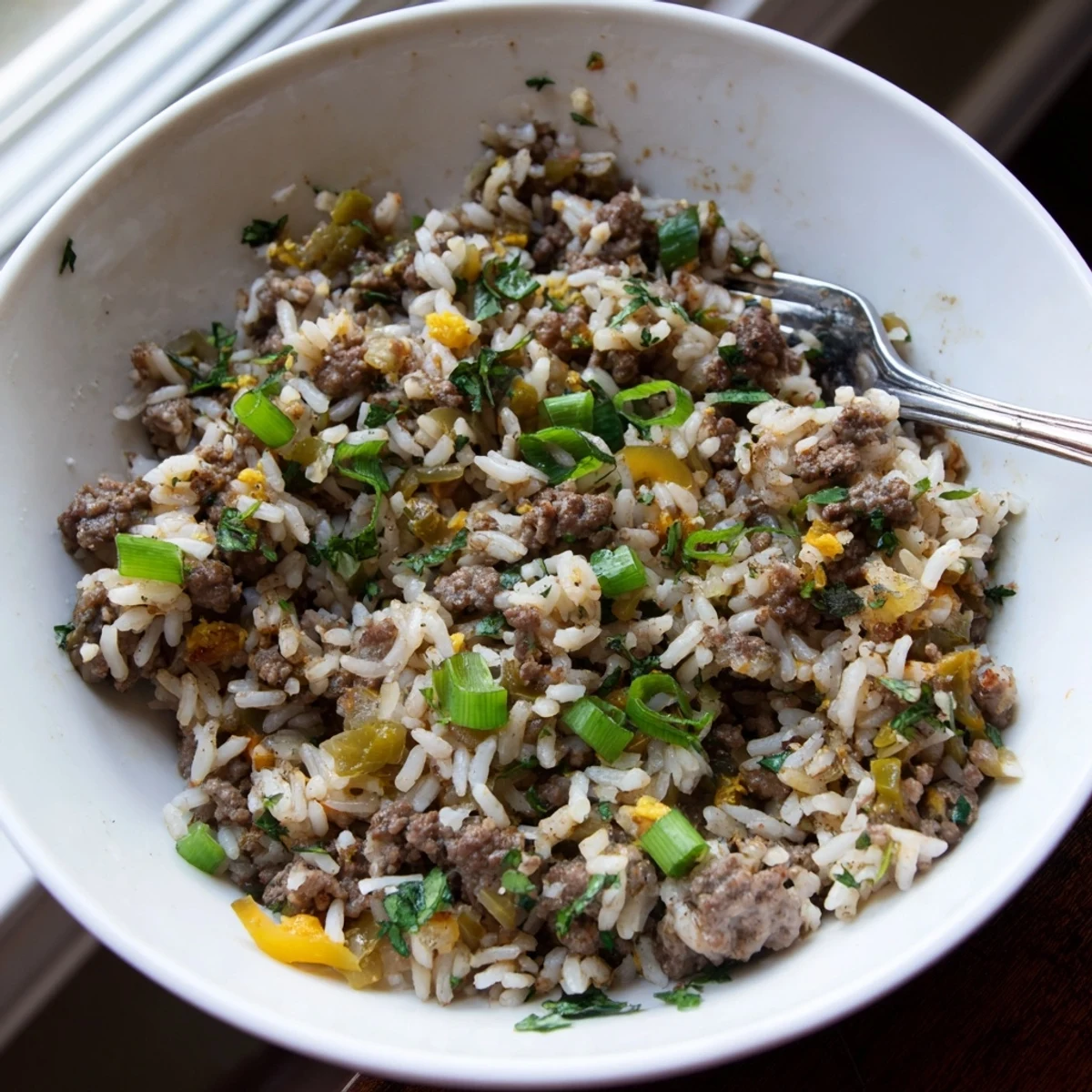 This rustic skillet of Mardi Gras dirty rice showcases browned ground beef, bell peppers, and aromatic Creole spices.  