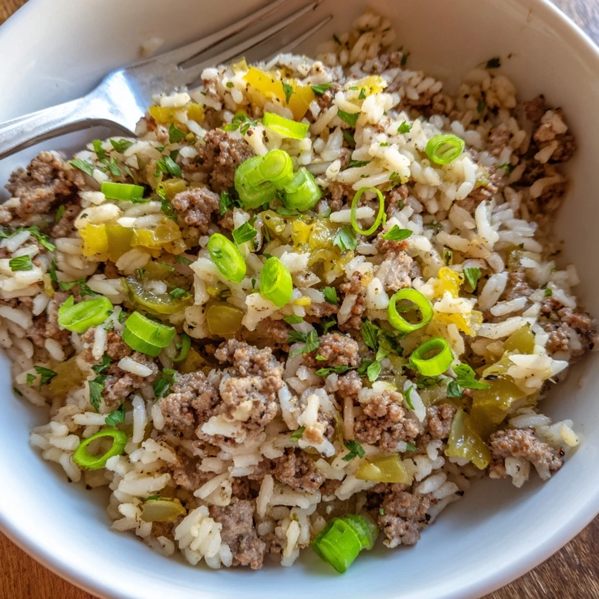 Steaming bowl of Mardi Gras dirty rice with ground beef, celery, and green onions, ready for a festive celebration.