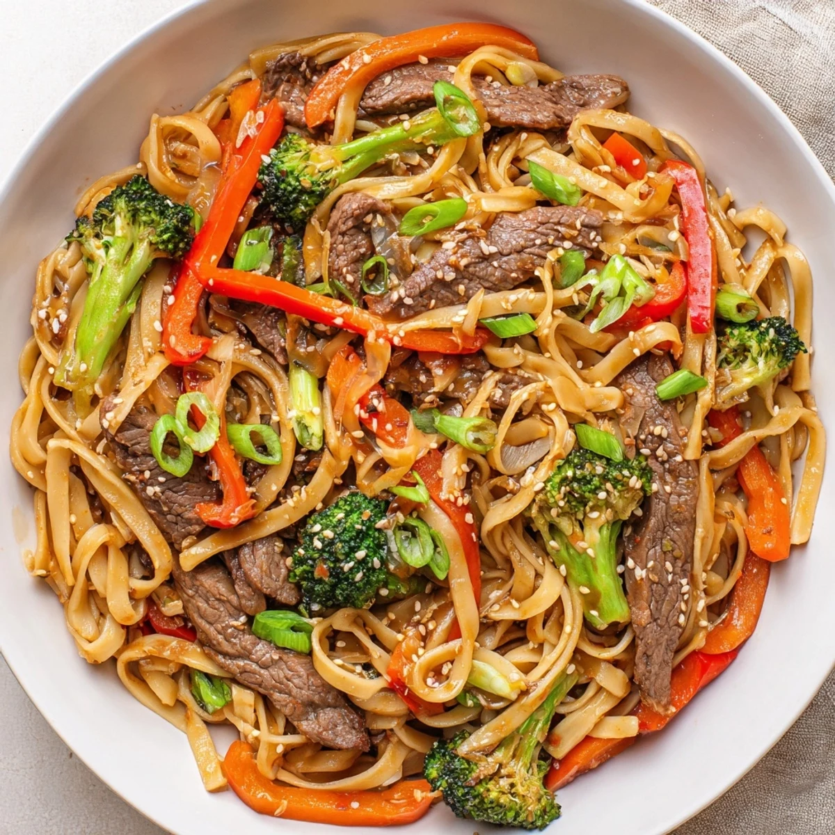 Tender beef strips and crisp broccoli florets tossed with lo mein noodles in a glossy sesame soy sauce.
