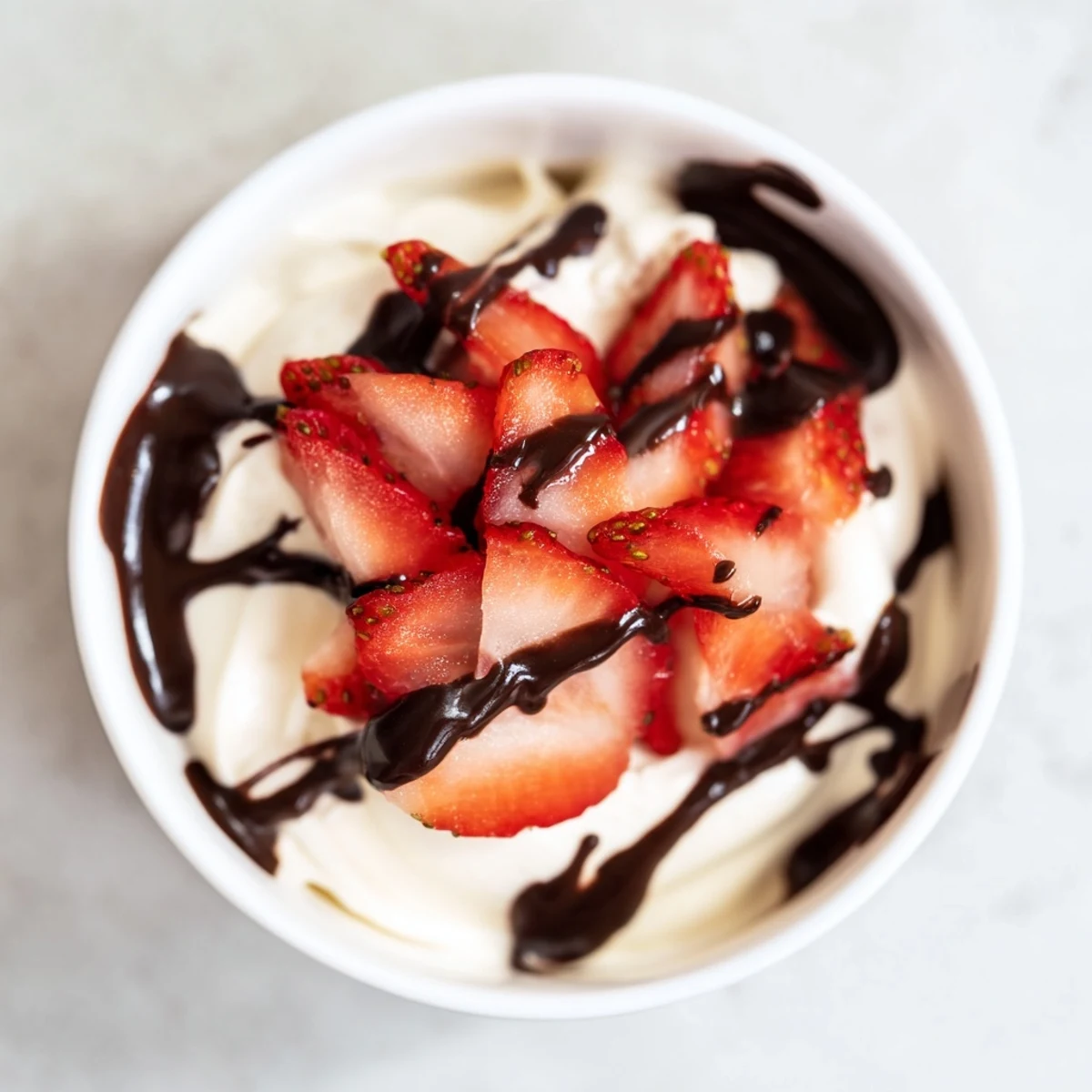 Chocolate Covered Strawberry Greek Yogurt in clear glass bowls, with luscious melted chocolate drizzle over fresh berries.