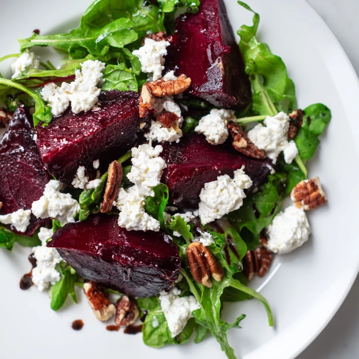 A vibrant platter of roasted beet and goat cheese salad features ruby-red beet wedges, soft cheese, and golden toasted pecans.