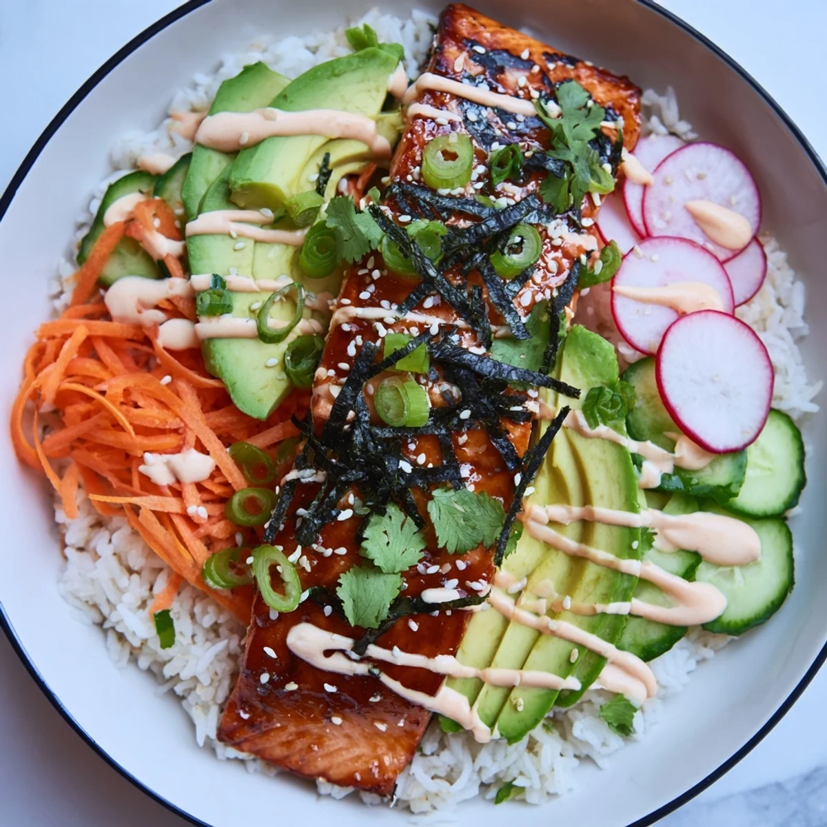 Glazed salmon sits atop fluffy rice with crunchy pickled carrots and zesty sriracha mayo for a fusion bowl.