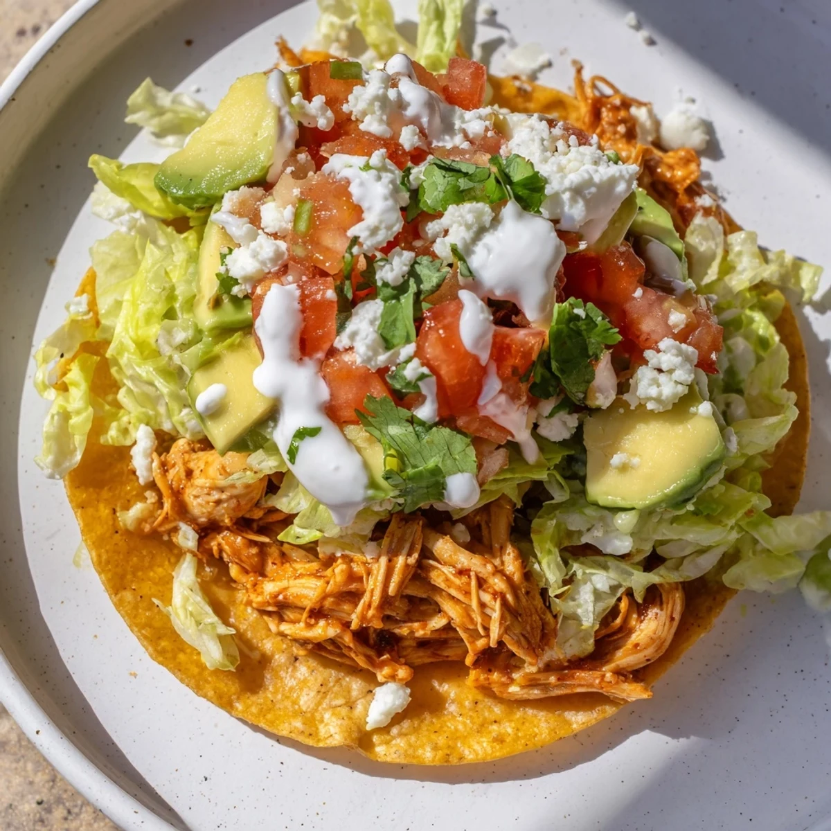 Golden crispy mini tostadas topped with seasoned shredded chicken, fresh salsa, and diced avocado.
