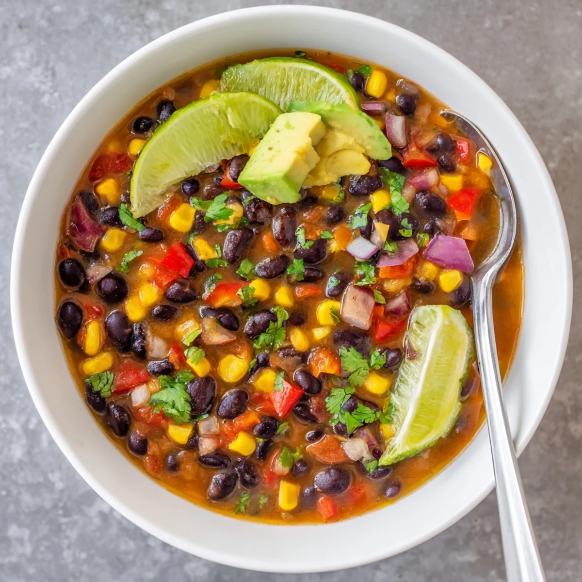 Hearty Black Bean Corn Chili Lime Delight served over rice with corn and cilantro toppings.