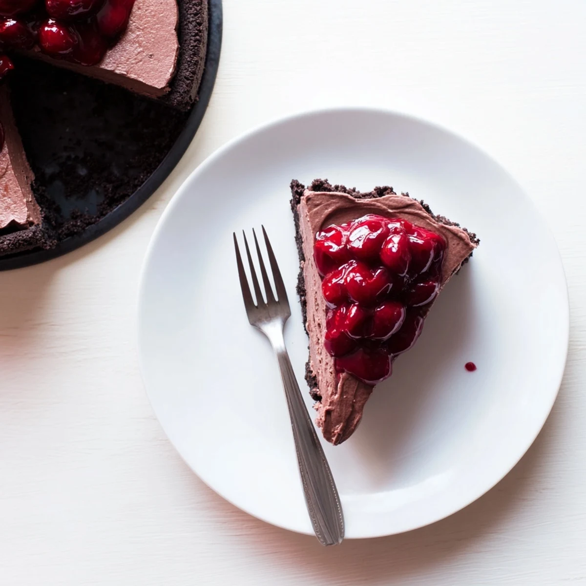 Decadent dark chocolate cherry cheesecake featuring smooth chocolate layers and fresh cherry swirl
