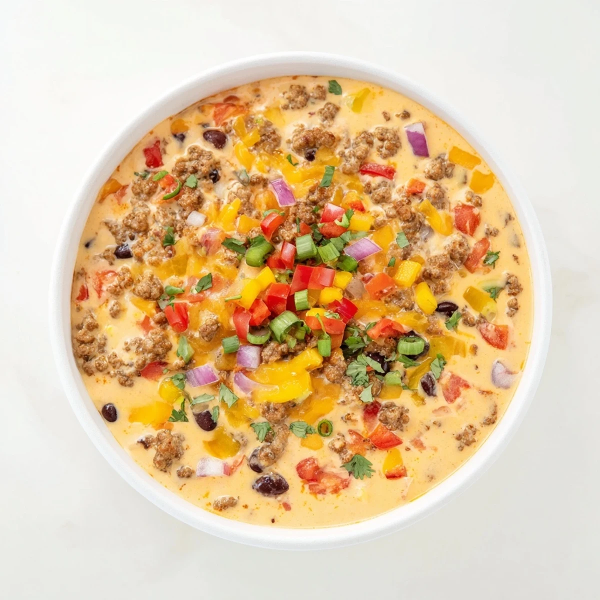 Rich Spicy Cowboy Queso Dip loaded with black beans, diced tomatoes, and spicy sausage ready for tortilla chips