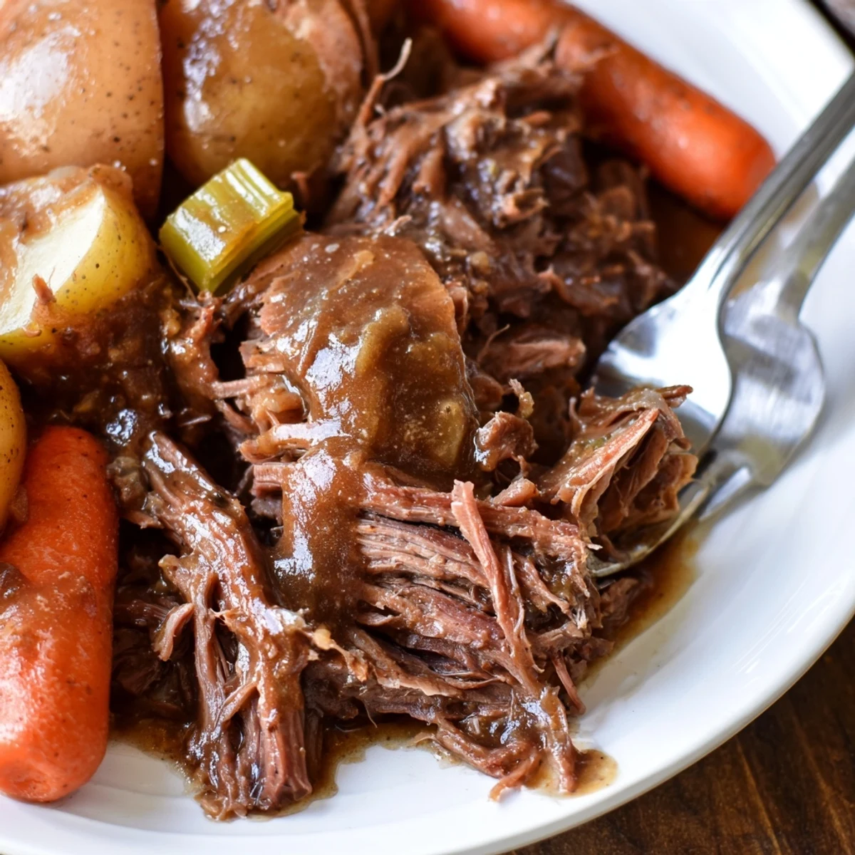 Golden brown Southern style pot roast plated with smooth mashed potatoes and crisp-tender green beans topped with velvety beef gravy