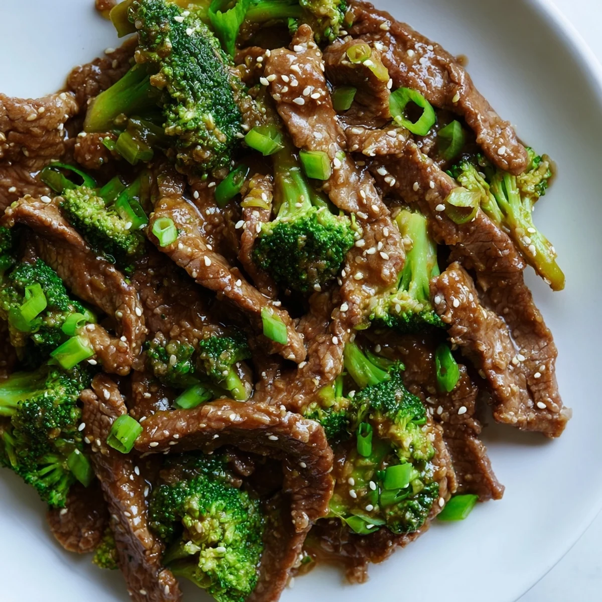 Golden glazed beef strips and bright green broccoli florets in savory Instant Pot sauce
