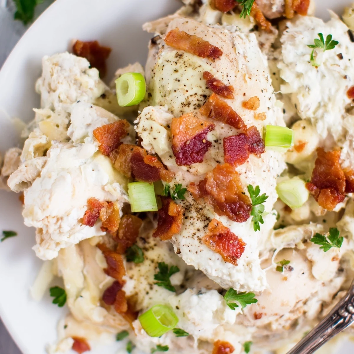 Tender Crockpot Million Dollar Chicken with rich cream cheese sauce garnished with crumbled bacon