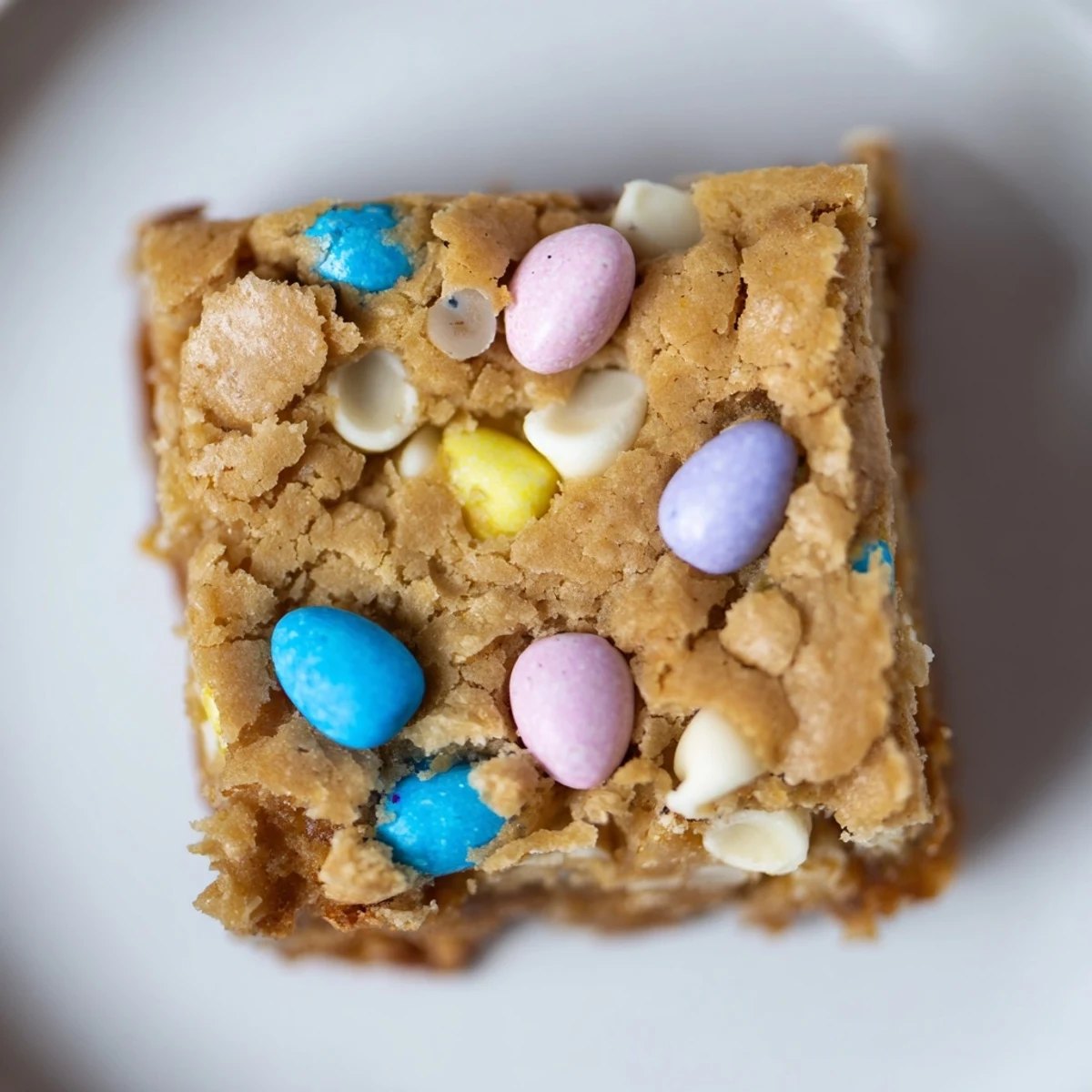Moist buttery Mini Cadbury Easter Egg blondies topped with colorful candy eggs drizzled in melted white chocolate