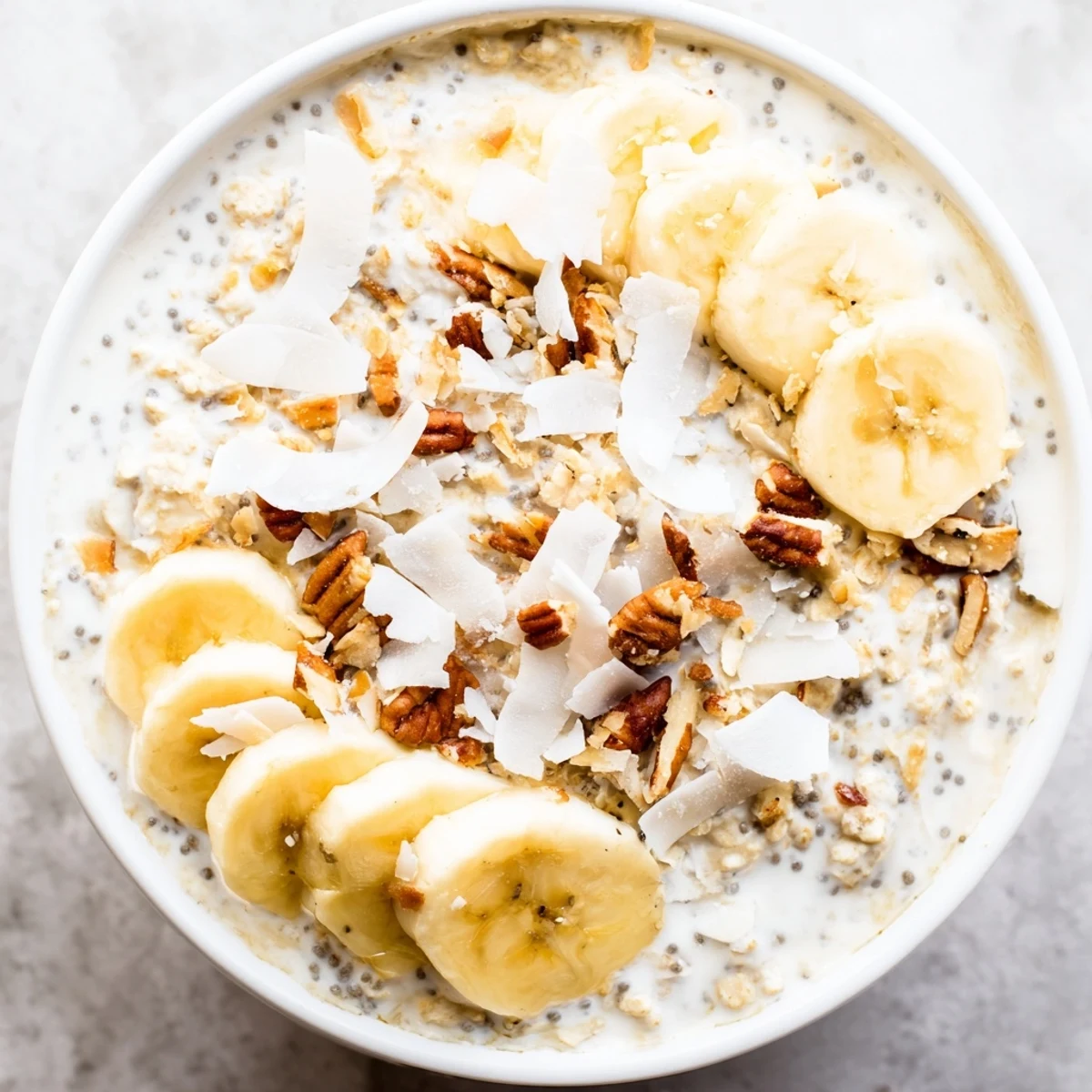 Chilled coconut cream pie overnight oats served in a jar with banana slices