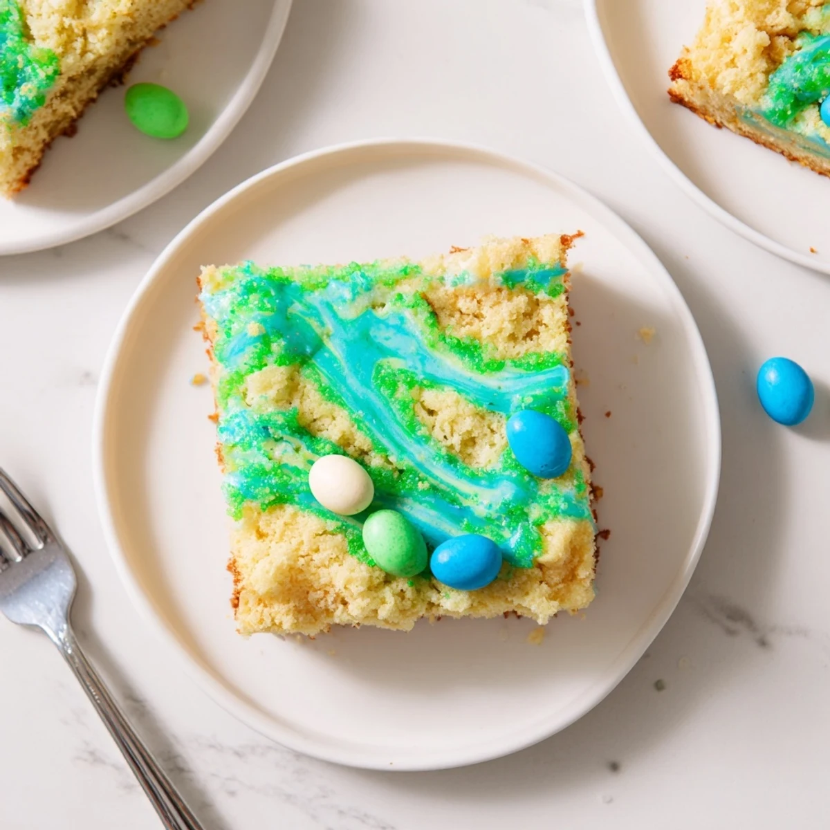 Robin Egg Snack Cake with pastel glaze drizzle topped with colorful candy-coated chocolate eggs