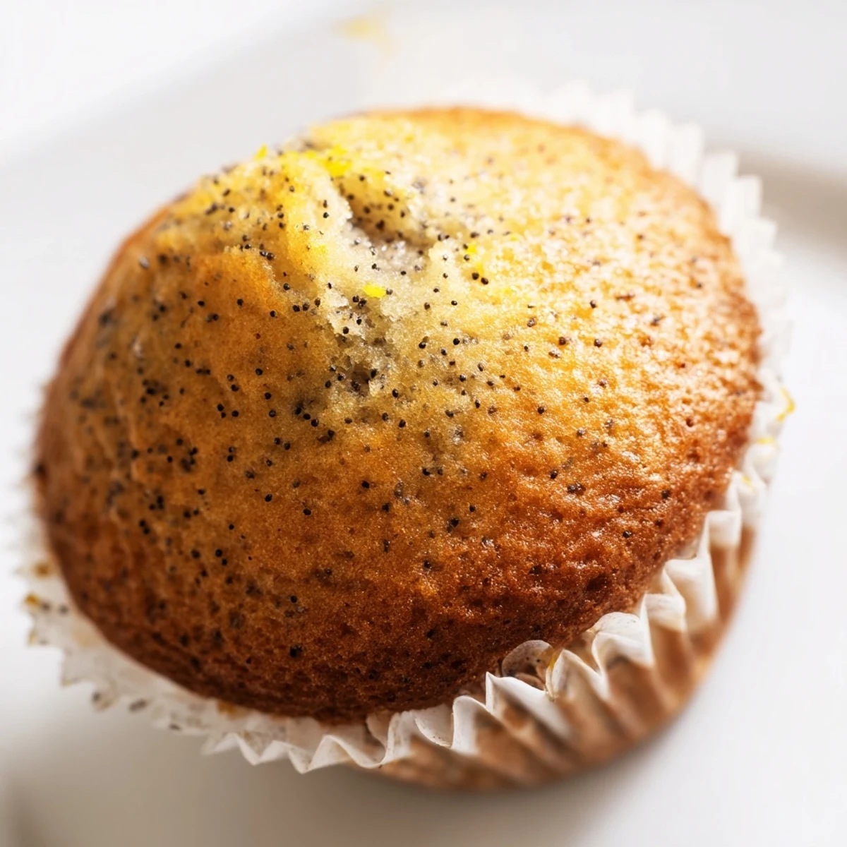 Golden lemon poppy seed muffins with domed tops fresh from the oven on a cooling rack