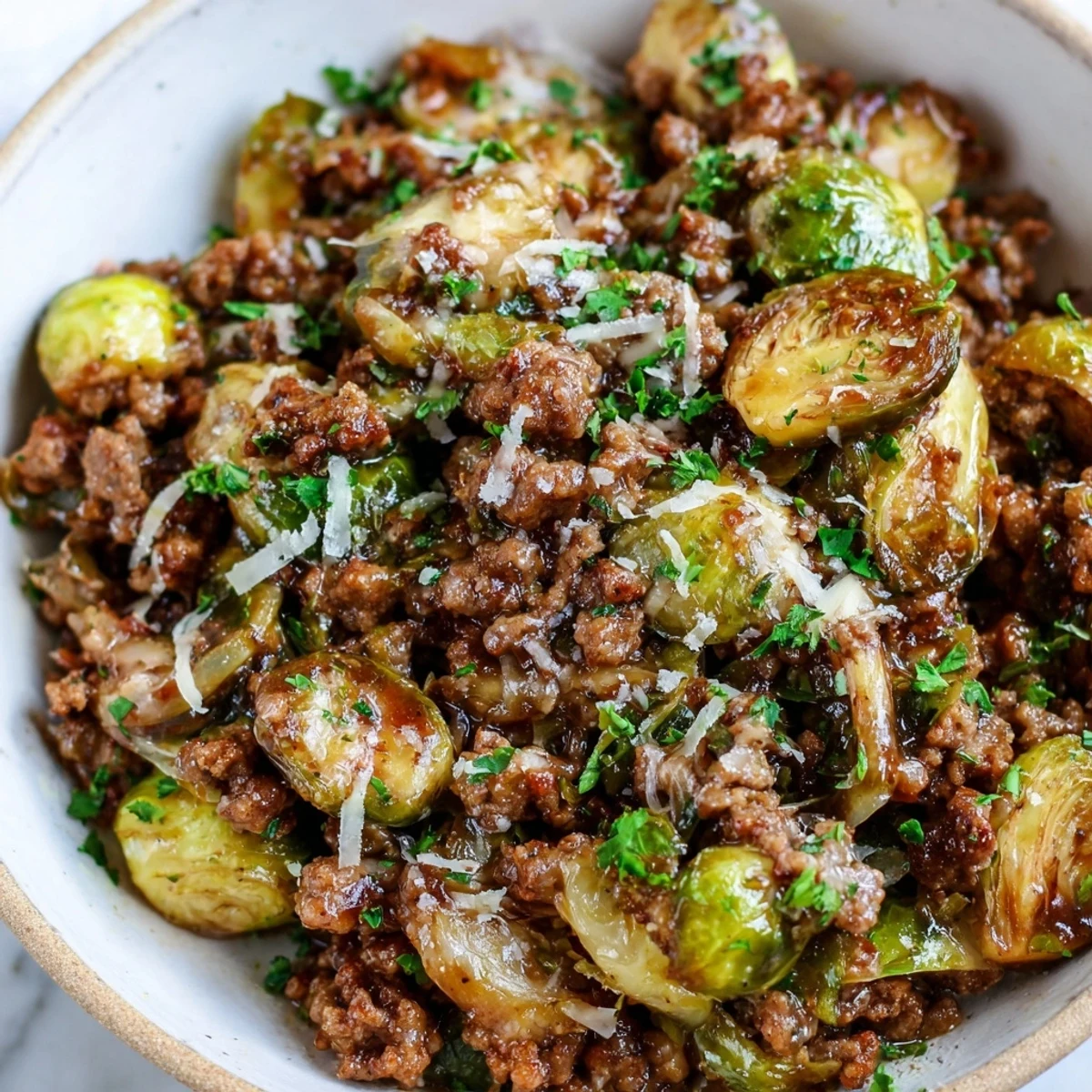 Hearty ground beef and Brussels sprouts skillet topped with grated Parmesan and parsley