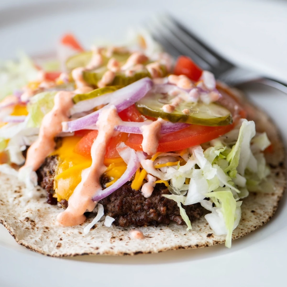 Juicy ground beef smash burger tacos drizzled with creamy burger sauce on flour tortillas