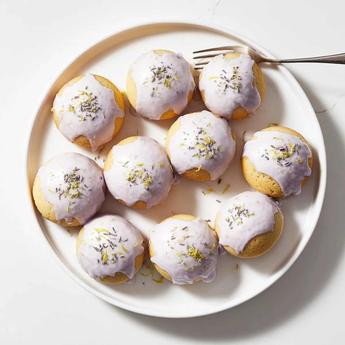 Golden mini lemon cakes with lavender glaze drizzled over tender crumb tops