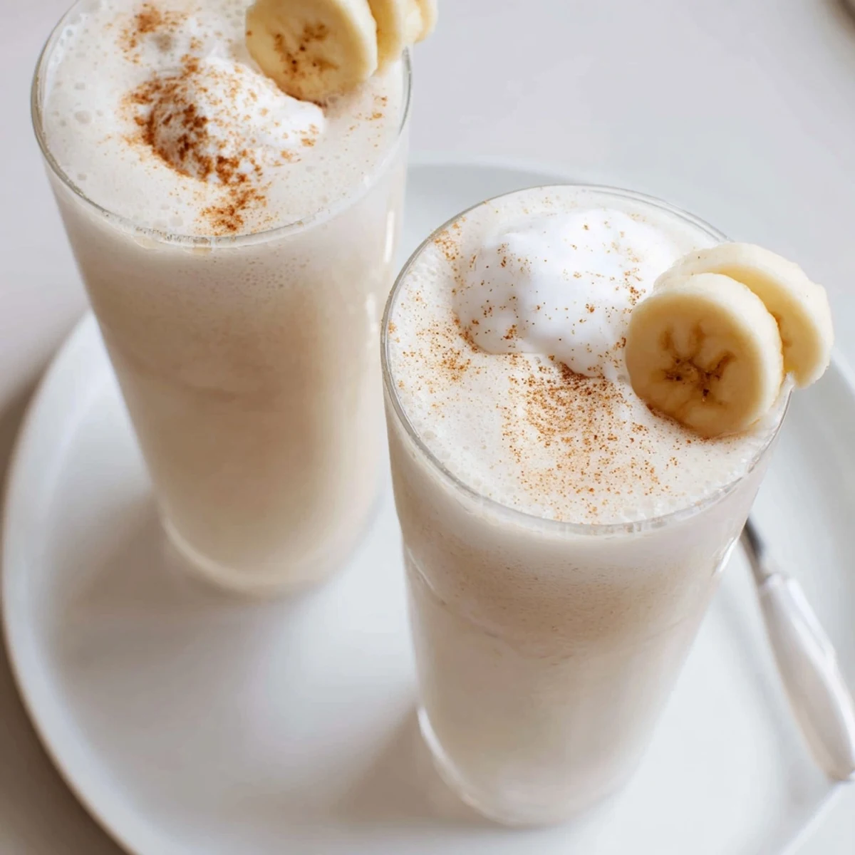 Velvety Vanilla Banana Shake poured from blender into two chilled glasses