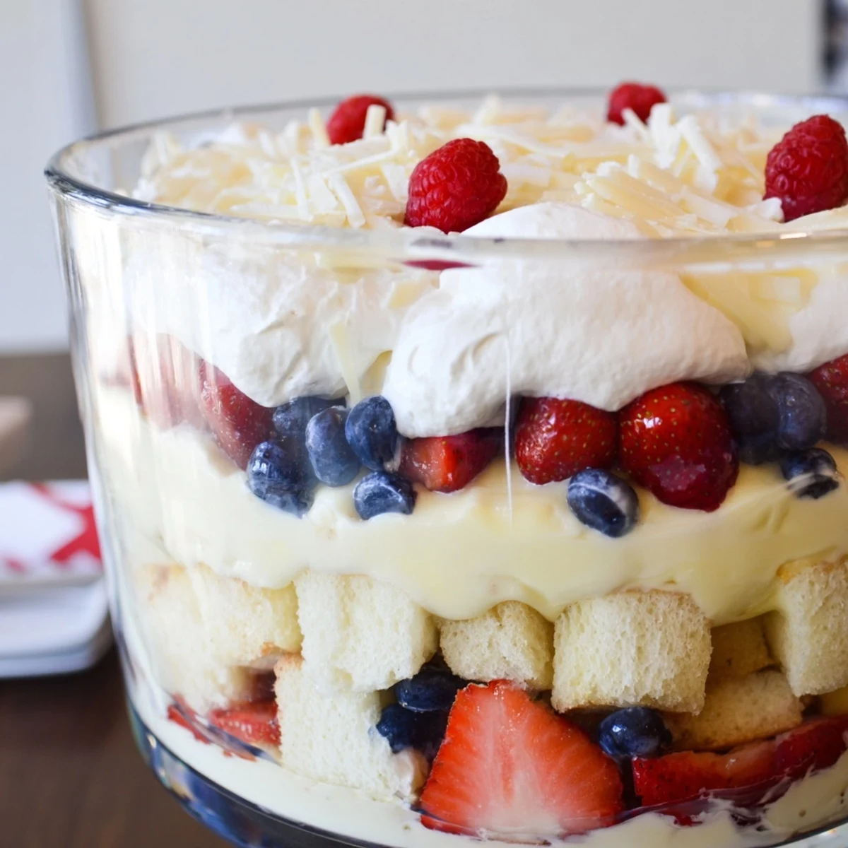 Chilled Red White And Blue Trifle topped with whipped cream and berries.