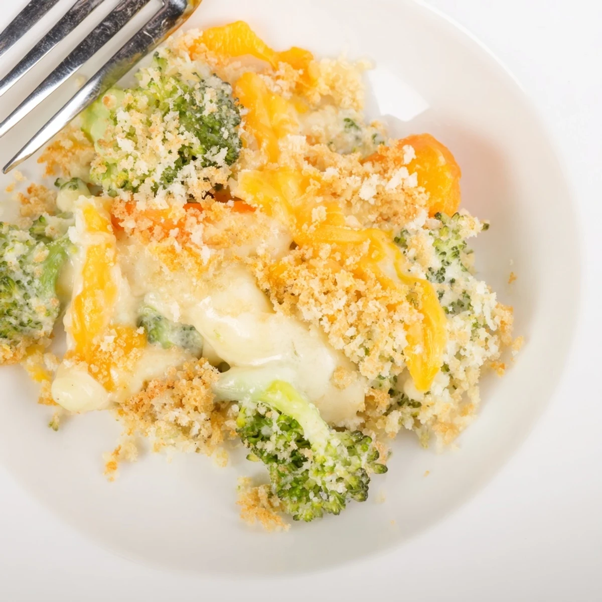 A slice of Cheese Bake Broccoli Carrots steaming on plate, buttery panko crust