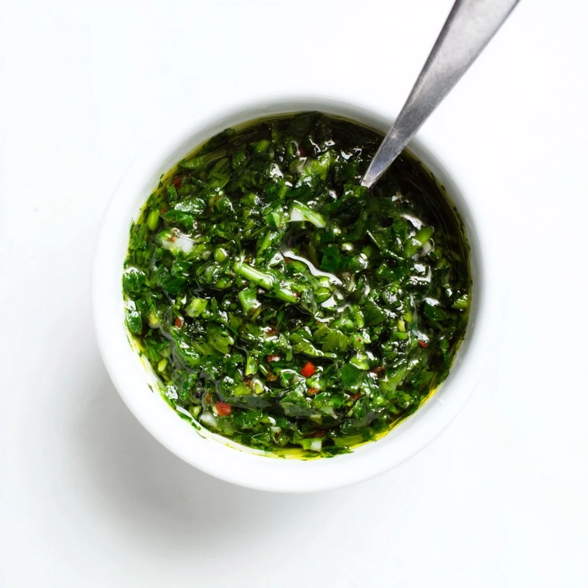 Vibrant green garlic scape chimichurri sauce drizzled generously over perfectly grilled juicy steak