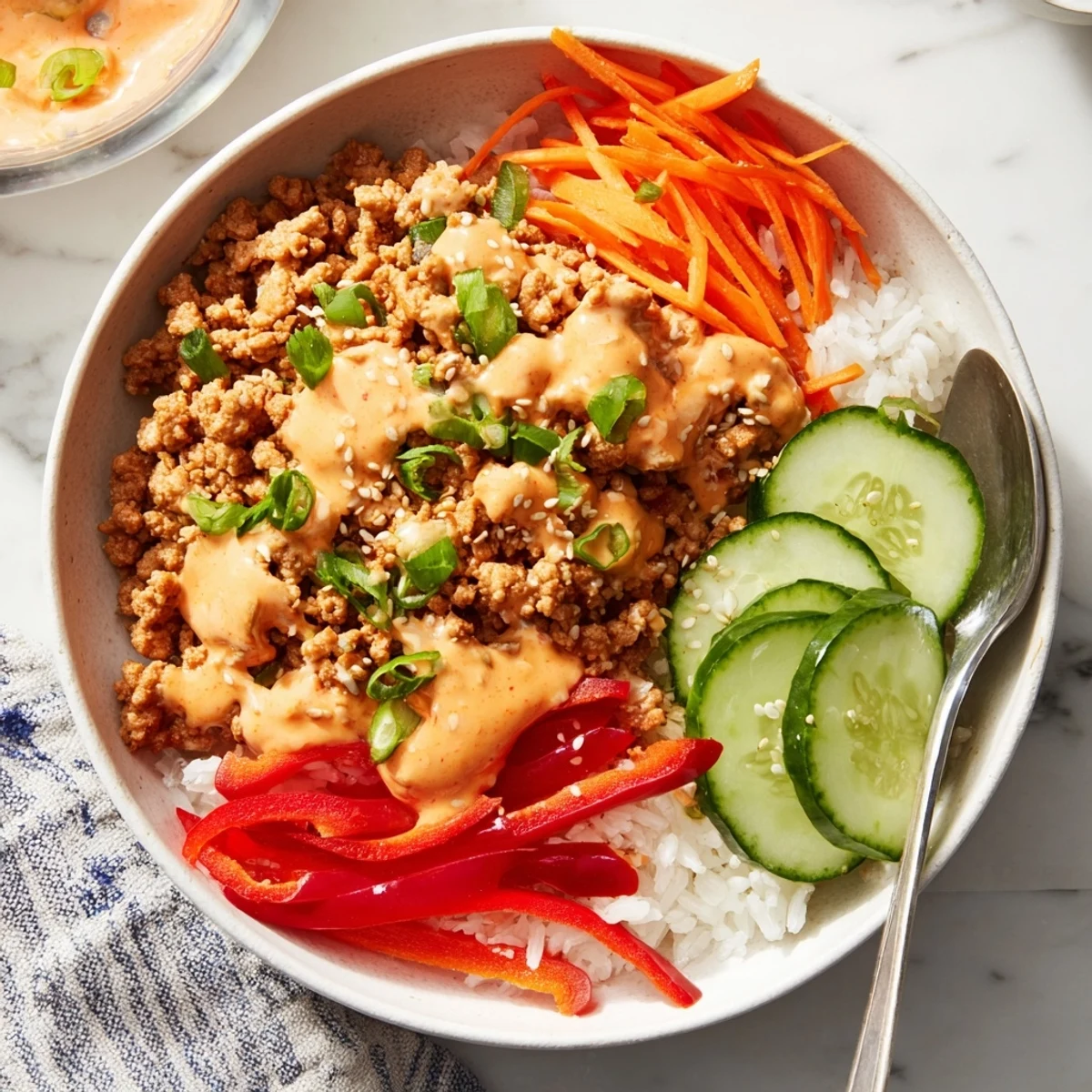 Ground Turkey Rice Bowls with Bang Bang Sauce drizzled over crisp veggies and fluffy jasmine rice.