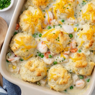 Spoon serving of Seafood Pot Pie with Cheddar Bay Biscuit Topping showing creamy shrimp and crab filling.  
