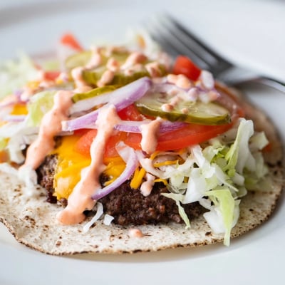 Juicy ground beef smash burger tacos drizzled with creamy burger sauce on flour tortillas