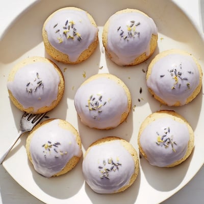 Mini lemon cakes with lavender glaze served on a dainty afternoon tea plate